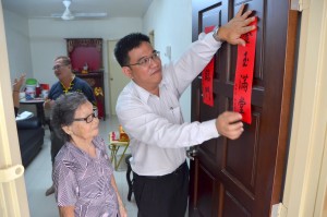 在苦等了18年后，86岁的賴金淑终于入住属于自己的新居，与家人们一起欢庆农历新年。旁为槟州首长政治秘书黄汉伟。（摄影：罗孙庭）