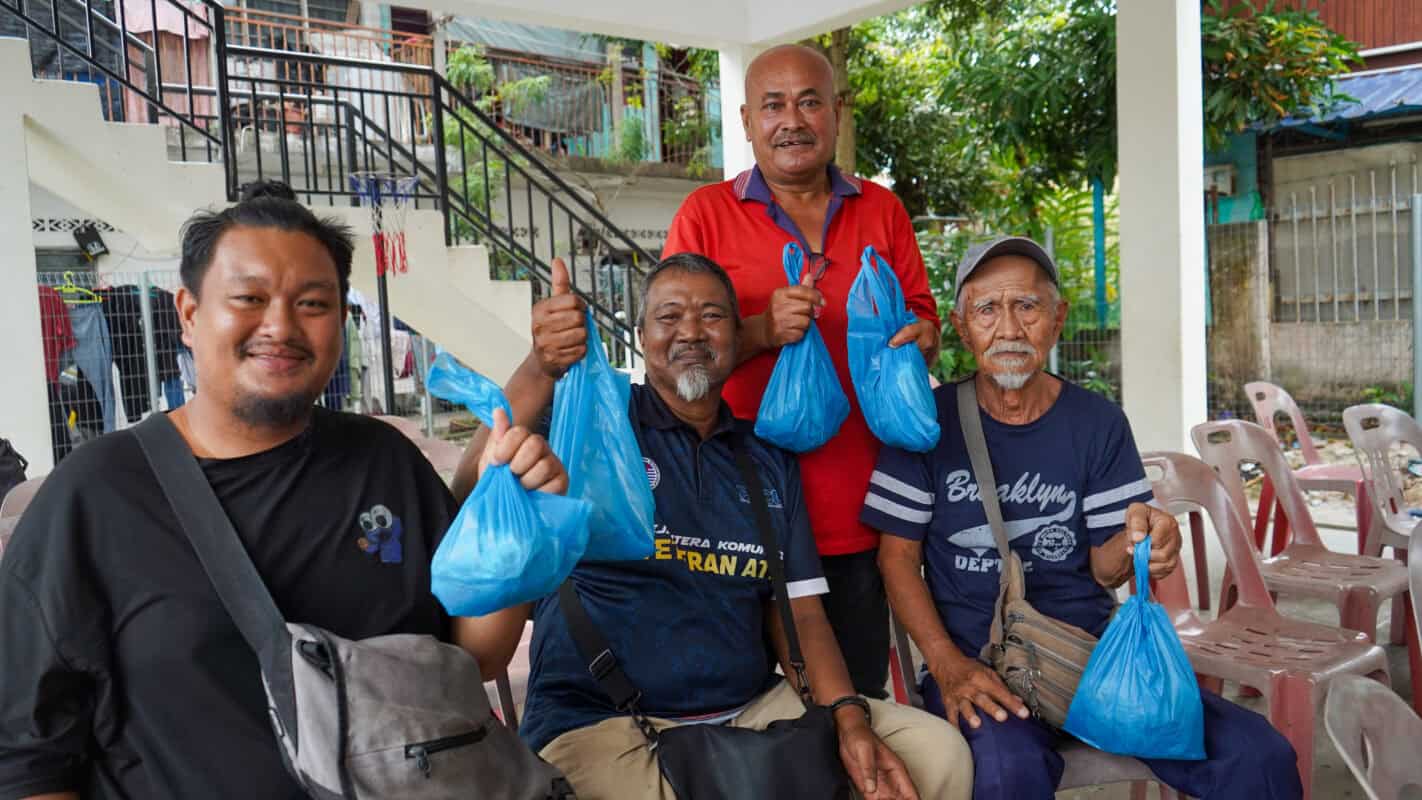 roslan (in red) and his fishermen friends are happy to receive the fresh meat during the eid adha fresh meat distribution pr